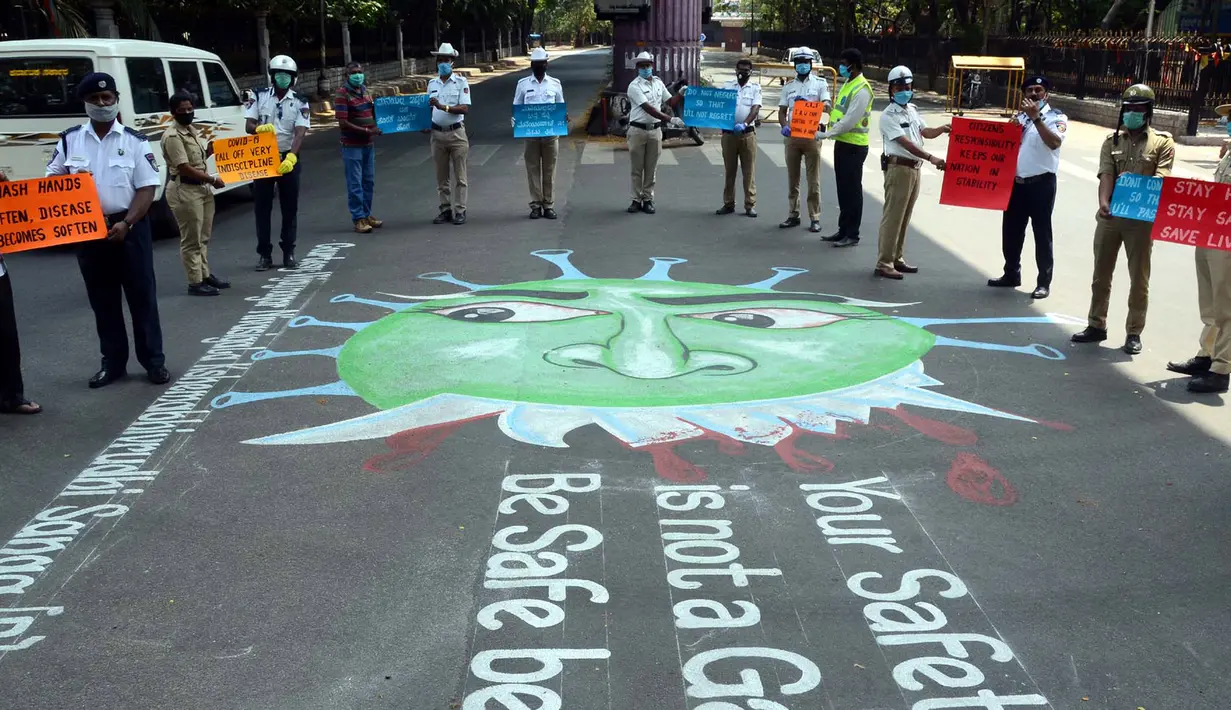 Petugas kepolisian berpartisipasi dalam kampanye untuk meningkatkan kesadaran masyarakat mematuhi lockdown yang diberlakukan pemerintah India sebagai langkah pencegahan COVID-19, dengan menggambar grafiti virus tersebut di semua persimpangan lalu lintas di Bangalore (3/4/2020). (Xinhua/Stringer)