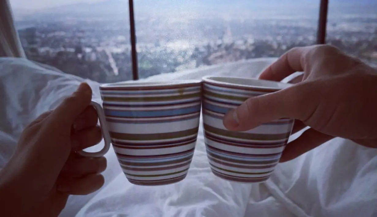 Gal Gadot memposting sebuah foto di Instagram yang memperlihatkan dirinya dan suaminya yang memegang cangkir berlatarkan pemandangan indah. (instagram/gal_gadot)