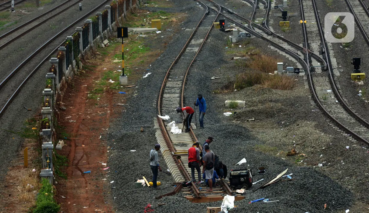 Pekerja menyelesaikan pengerjaan rangkaian rel di Depo Cipinang, Jakarta, Sabtu (16/11/2019). Proyek pembangunan Double-Double Track yang rampung pada awal 2019 masih dalam perbaikan di lajur Depo Cipinang. (merdeka.com/Imam Buhori)
