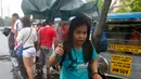 Penduduk sekitar tetap menjalankan aktivitas sehari-hari meskipun hujan lebat membanjiri Manila, Filipina, Kamis (27/7). Diperkirakan akan meningkatnya musim penghujan di wilayah barat daya Manila hingga akhir Juli. (AP/Bullit Marquez)