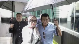 Rhoma Irama memayungi istrinya Ricca Rachim saat hadir dalam konferensi pers indosiar Ramadhan Penuh Berkah di Jakarta, Kamis (26/4). Pernikahan Rhoma Irama dan Ricca Rahim yang telah berusia 34 tahun ini jauh dari gosip. (Liputan6.com/Faizal Fanani)