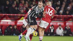 Pemain Manchester United, Christian Eriksen, diadang pemain Nottingham Forest, Nicolas Dominguez, pada laga pekan ke-20 Premier League 2023/2024, Minggu (31/12/2023) dini hari WIB. Setan Merah tak mampu berbuat banyak di markas Nottingham Forest. (AP Photo/Rui Vieira)