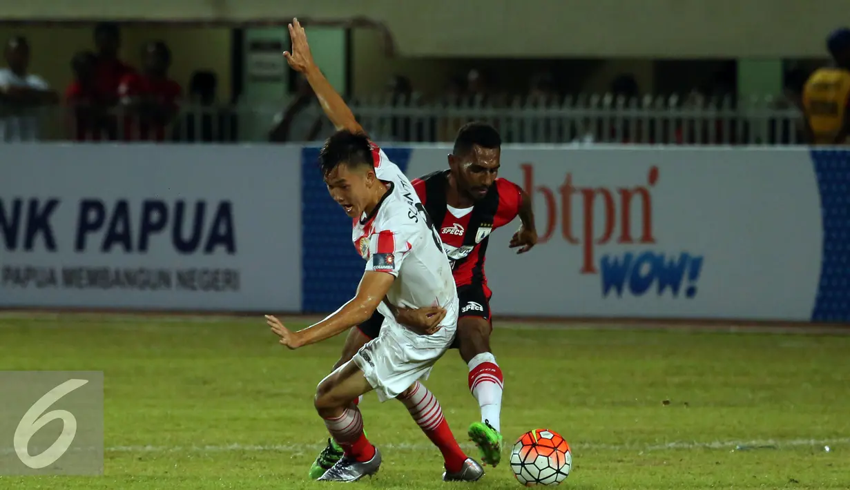 Penyerang Persija Sutanto Tan ditahan pemain Persipura saat laga perdana Torabika Soccer Championship presented by IM3 Ooredoo di Stadion Mandala Jayapura, Papua, Jumat (29/4/2016).Kedua tim bermain imbang 1-1. (Liputan6.com/Helmi Fithriansyah)