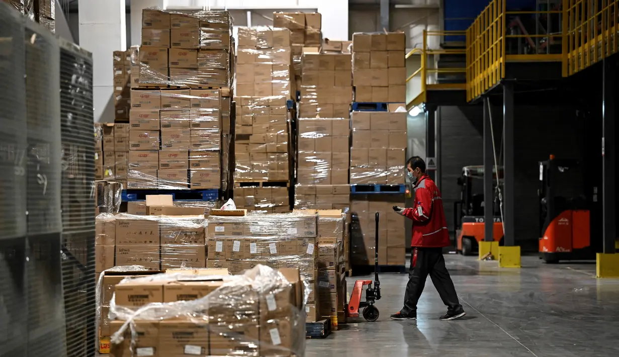 Seorang pekerja bersiap mentransfer paket untuk pengiriman menjelang festival belanja Singles' Day yang jatuh pada 11 November, di gudang JD.com di Beijing, Selasa (9/11/2021). Hari belanja online nasional atau single day di China menjadi festival belanja online terbesar di dunia. (Giok GAO / AFP)