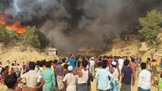 Pengungsi Rohingya menyaksikan asap membubung menyusul kebakaran di kamp pengungsi Rohingya di Balukhali, Bangladesh selatan (22/3/2021). Api menghancurkan ratusan tempat penampungan dan menyebabkan ribuan orang kehilangan tempat tinggal, kata pejabat dan saksi. (AP Photo/Shafiqur Rahman)