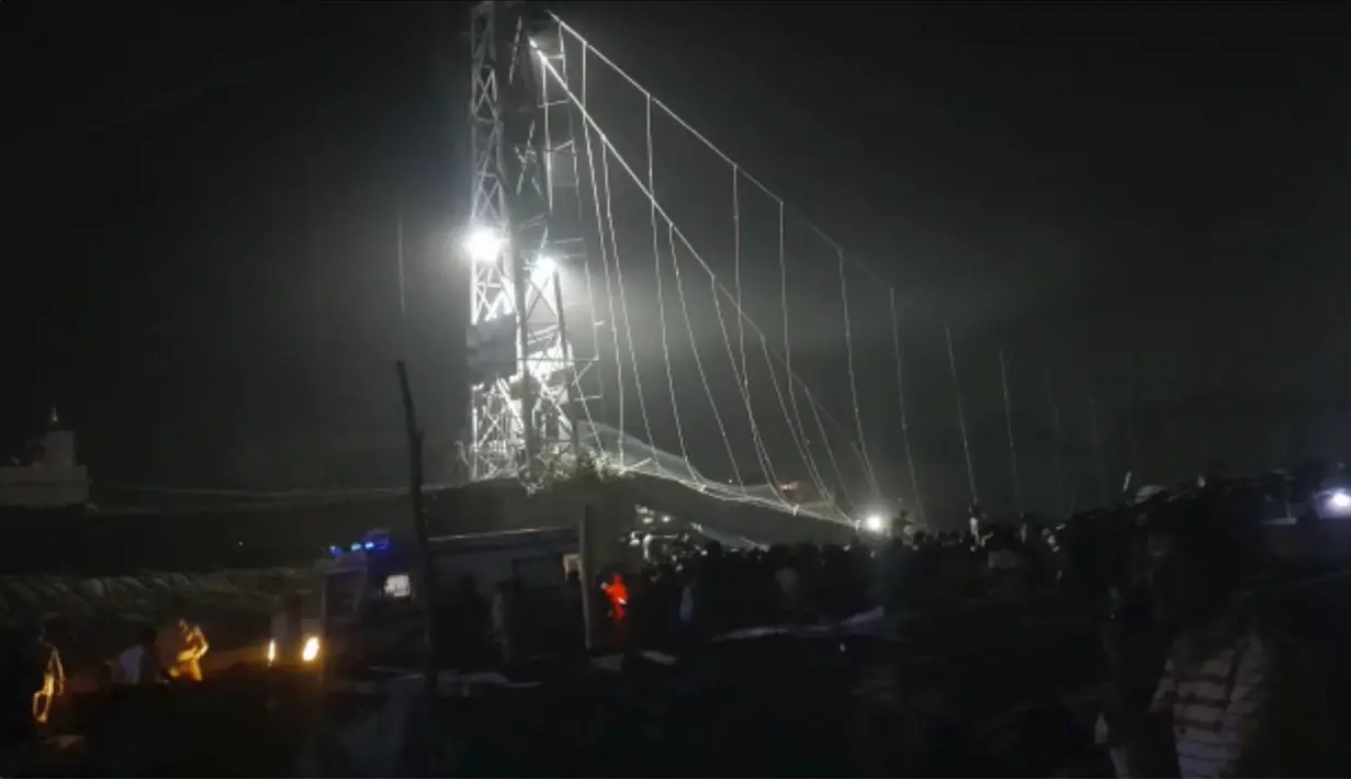 Tim penyelamat bekerja pada malam hari setelah jembatan kabel di seberang sungai Machchu runtuh di distrik Morbi, negara bagian Gujarat barat, India, Minggu, 30 Oktober 2022. Puluhan orang tewas dan banyak yang dikhawatirkan terluka dalam kecelakaan itu. (AP/Rajesh Ambaliya)