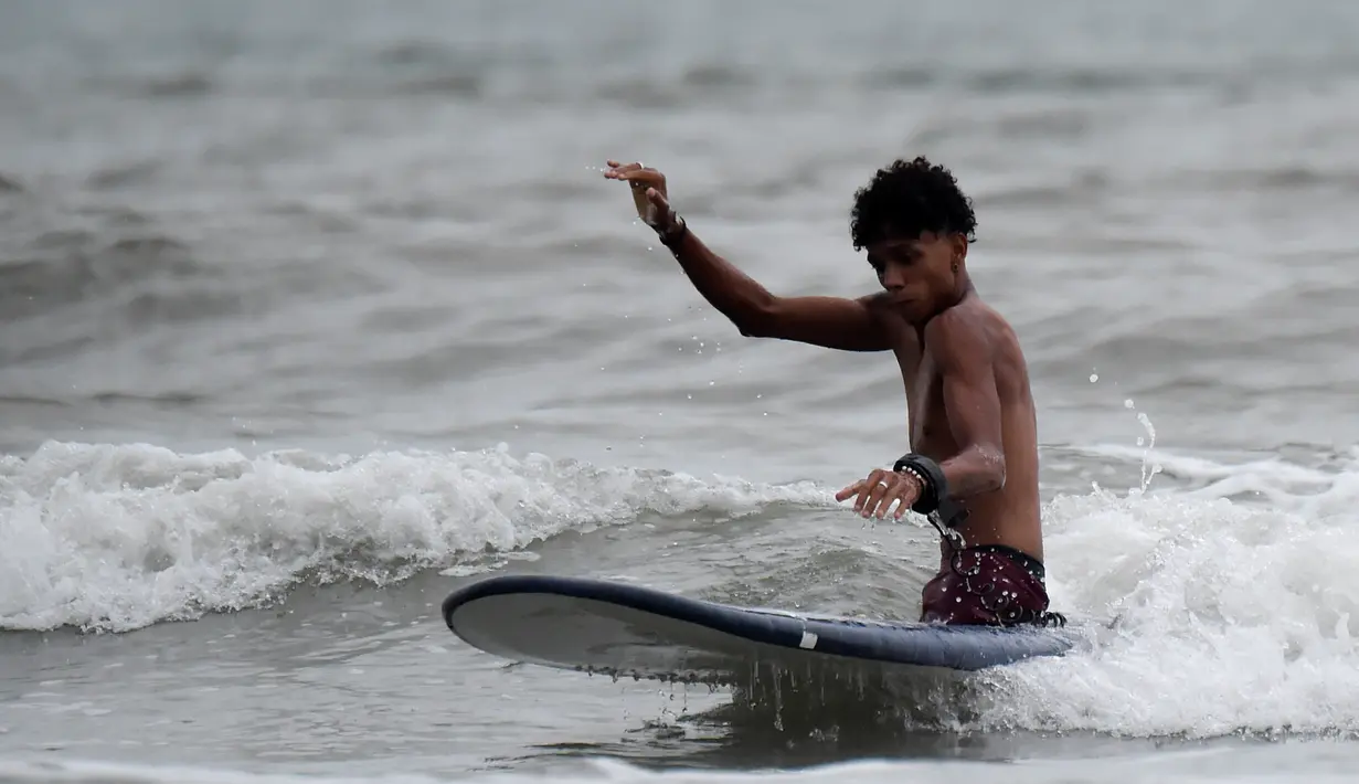 Imigran Venezuela, Alfonso Mendoza alias Alca bermain surfing di Puerto, Kolombia, 27 September 2018. Lahir tanpa kaki dan ditinggalkan oleh orangtuanya, membuat Alca sempat berpikir untuk bunuh diri. (Raul ARBOLEDA/AFP)