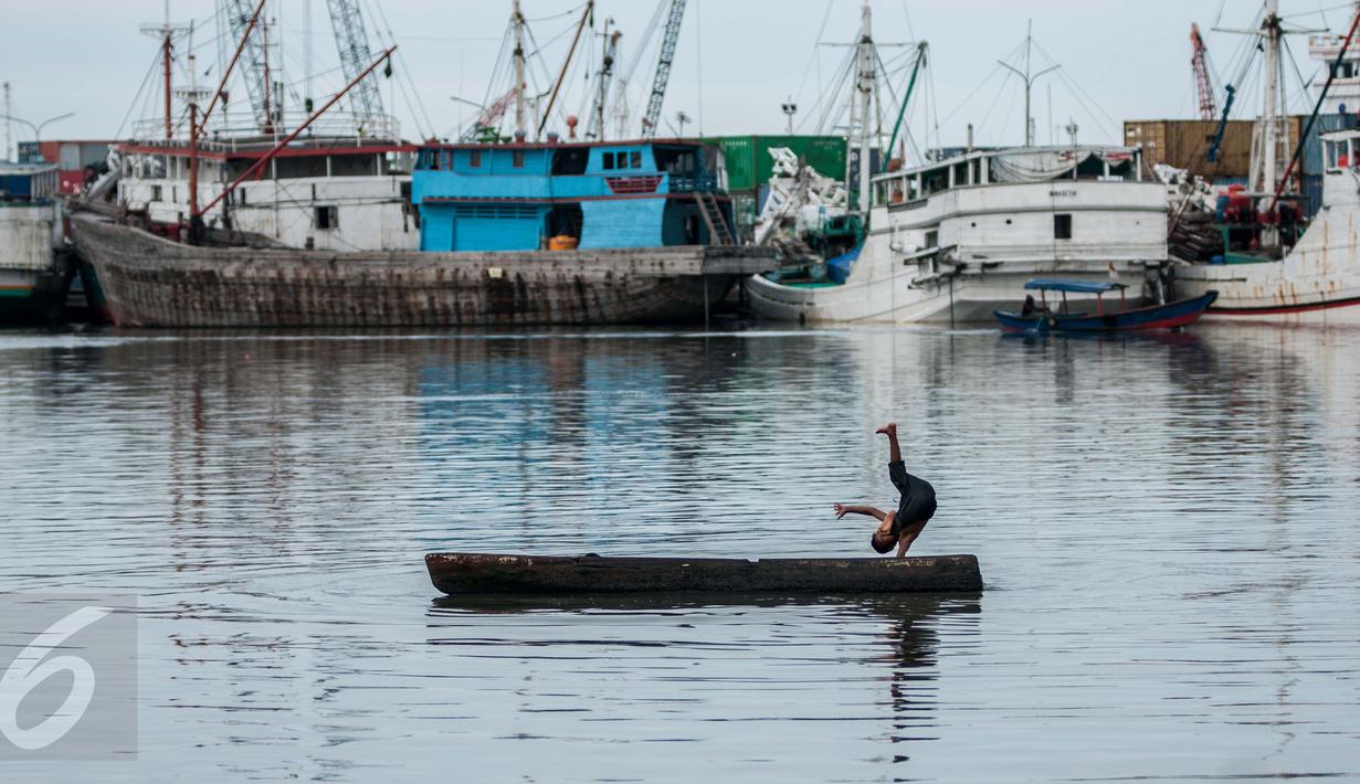 Seorang anak bermain di atas sampan di Kampung Akuarium, Penjaringan, Jakarta Utara, Senin (30/1). Rencana tahap pertama revitalisasi  Kampung Akuarium adalah membuat tanggul setinggi 3,5 meter dari tepi laut. (Liputan6.com/Gempur M Surya)