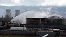 Petugas pemadam mencoba memadamkan bara api yang masih tersisa di salah satu tangki kilang minyak di Haifa, utara kota Israel, Minggu (25/12). Penyebab kebakaran di salah satu tangki kilang minyak tersebut masih belum diketahui. (REUTERS/Baz Ratner)
