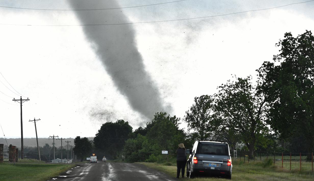 Seorang wanita mengamati tornado besar yang melewati daerah perumahan dari selatan Wynnewood, Kota Oklahoma, Senin (9/5). Tornado menelan korban sebanyak dua orang dan tiga rumah penduduk hancur. (Josh EDELSON/AFP)