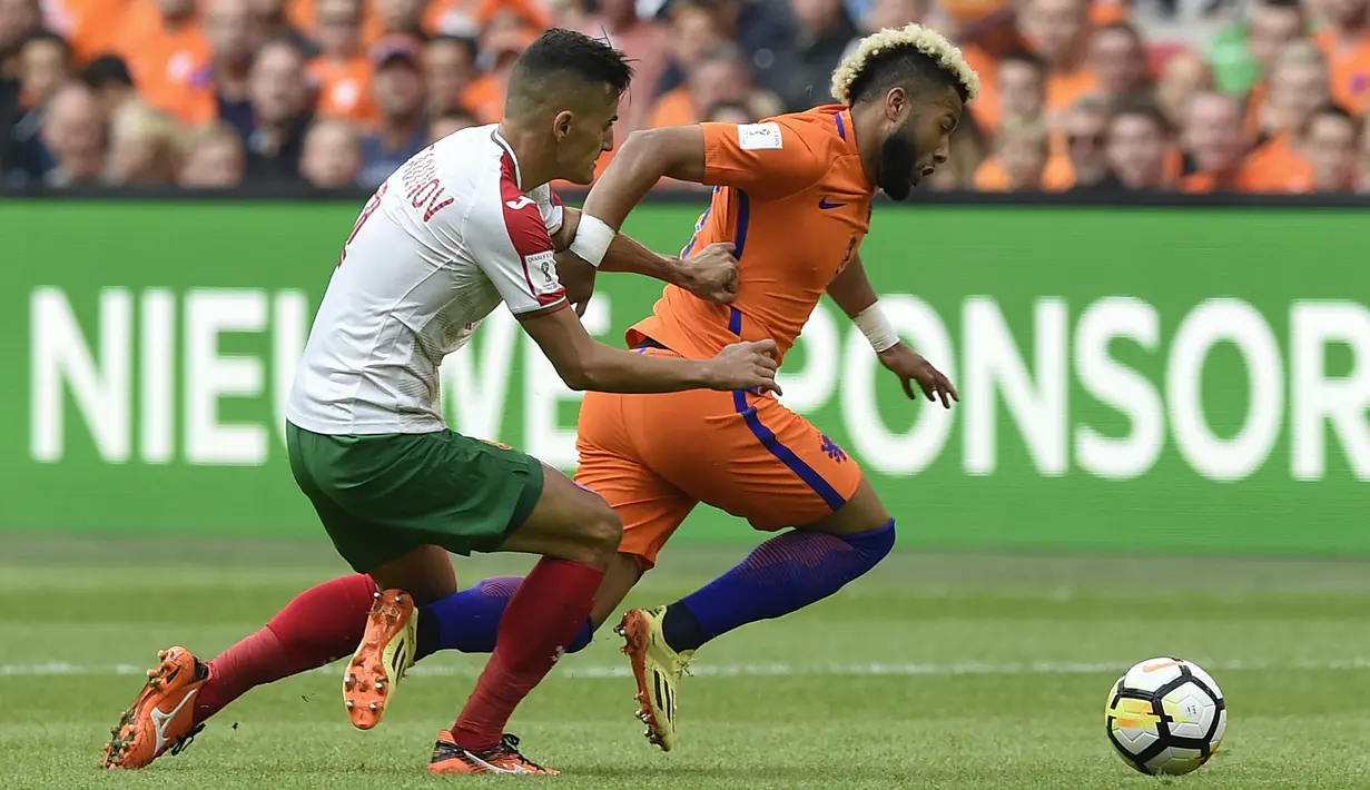 Pemain Belanda, Tonny Vilhena (kanan) melewati adangan pemain Bulgaria, Georgi Kostadinov pada laga grup A kualifikasi Piala Dunia 2018 di Amsterdam, (3/9/2017). Belanda menang 3-1. (AFP/John Thys)
