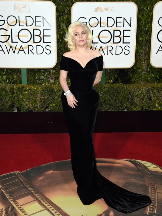 Penyanyi Lady Gaga berpose di karpet merah ajang penghargaan film tahunan, Golden Globes 2016 di Beverly Hilton Hotel, California, Minggu (10/1). Pelantun hits 'Judas' tersebut tampil glamour dengan gaun hitam Versace.  (Jason Merritt/Getty Images/AFP)