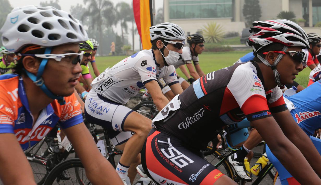Beberapa pebalap memakai masker  untuk melindungi diri dari kabut asap di Etape 6 Tour de Singkarak 2015, Kamis (8/10/2015). (Bola.com/Arief Bagus)