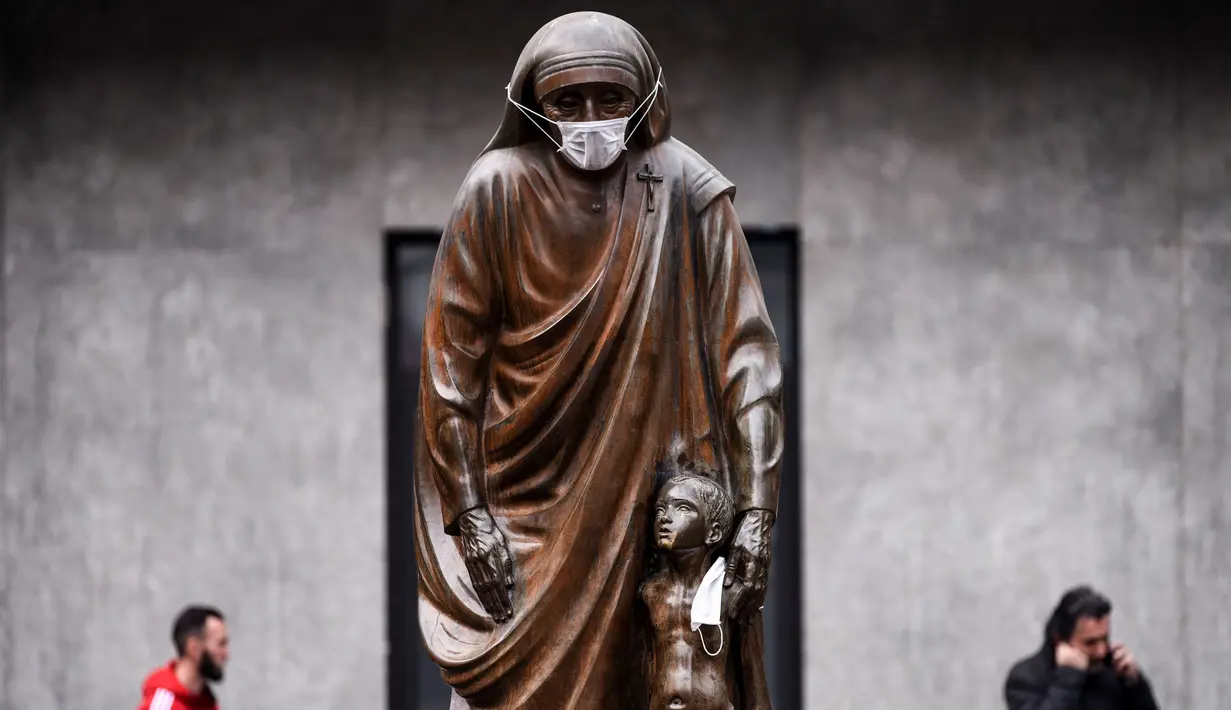 Masker terpasang pada wajah patung Bunda Teresa di Pristina, Kosovo, Kamis (19/12/2019). Selama beberapa bulan terakhir, Pristina terdaftar sebagai salah satu kota dengan kualitas udara terburuk di dunia. (Armend NIMANI/AFP)