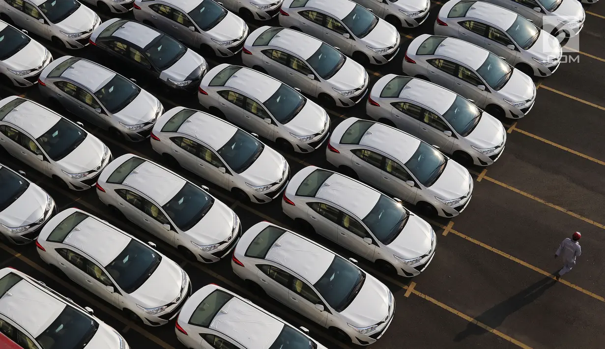 Pekerja berjalan di depan mobil yang siap diekspor terparkir di IPC Car Terminal, PT IKT, Pelabuhan Tanjung Priok, Jakarta, Kamis (11/7/2019). Kemenperin menargetkan ekspor mobil dari Indonesia mencapai 450 ribu unit pada tahun 2019. (Liputan6.com/Johan Tallo)