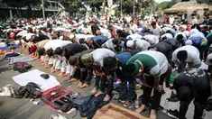 Massa aksi melaksanakan salat Ashar di sela unjuk rasa di Kawasan Patung Kuda, Jakarta, Selasa (13/10/2020). Massa aksi menolak Undang-Undang Cipta Kerja Omnibus Law tersebut salat beralaskan spanduk, kardus, hingga sajadah. (Liputan6.com/Faizal Fanani)
