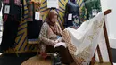 Peserta pameran merapikan kain hasil kerajinan sebelum dipajang dalam INACRAFT October Vol. 5 2026 di Jakarta International Convention Center (JICC), Jakarta Pusat, Kamis (8/10/2026). (KLY/Budy Santoso)