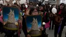 Sejumlah wanita membawa poster yang menyimbolkan gambar Our Lady of Socavon saat mengikuti prosesi untuk menghormati santo pelindung mereka, di Oruro, Bolivia (1/3). Mereka mendadak melakukan prosesi ini. (AP Photo/Juan Karita)