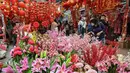 Seorang perempuan melihat dekorasi bunga menjelang Tahun Baru Imlek di Hong Kong pada 26 Januari 2022. Tahun Baru Imlek untuk masyarakat Tionghoa atau China di seluruh dunia pada tahun ini akan jatuh pada tanggal 1 Februari 2022. (Peter PARKS / AFP)