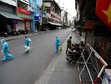 Petugas medis yang mengumpulkan sampel tes pada hari pertama pemberlakuan lockdown dari warga yang melintas di Kota Ho Chi Minh, Vietnam, Jumat (9/7/2021). Pemerintah Vietnam memberlakukan lockdown dua minggu di Kota Ho Chi Minh. (AFP/Huu Khoa)