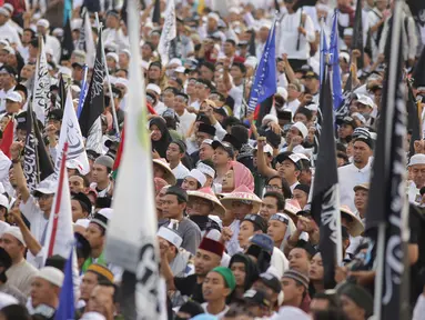 Umat muslim mengikuti aksi reuni 212 di kawasan silang Monas, Jakarta, Minggu (2/12). Bendera dan panji-panji terlihat diusung para peserta aksi reuni akbar 212. (Liputan6.com/Herman Zakharia)