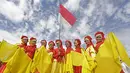 Penari mengibarkan bendera Merah-Putih usai beraksi pada penutupan Tour de Singkarak 2016 di Kota Padang, Sumatera Barat, (14/8/2016). (Bola.com/Nicklas Hanoatubun)