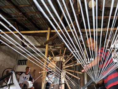 Pekerja memintal benang di sebuah industri rumahan yang ada di kawasan Kebayoran Lama, Jakarta, Minggu (11/5/2025). (Liputan6.com/Angga Yuniar)