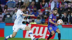 Bek Barcelona, Jordi Alba mengumpang bola dari kawalan pemain Dinamo Kyiv, Tomasz Kedziora pada pertandingan lanjutan Grup E Liga Champions di di stadion Camp Nou di Barcelona, Spanyol, Rabu (20/10/2021). Barcelona menang tipis atas Dinamo Kyiv dengan skor 1-0. (AP Photo/Joan Monfort)