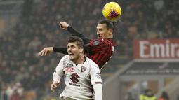 Penyerang AC Milan, Zlatan Ibrahimovic berebut bola udara dengan bek Torino, Lyanco  pada pertandingan lanjutan Liga Serie A Italia di stadion San Siro, di Milan, Italia, (18/2/2020). Milan menang tipis atas Torino 1-0. (AP Photo/Antonio Calanni)