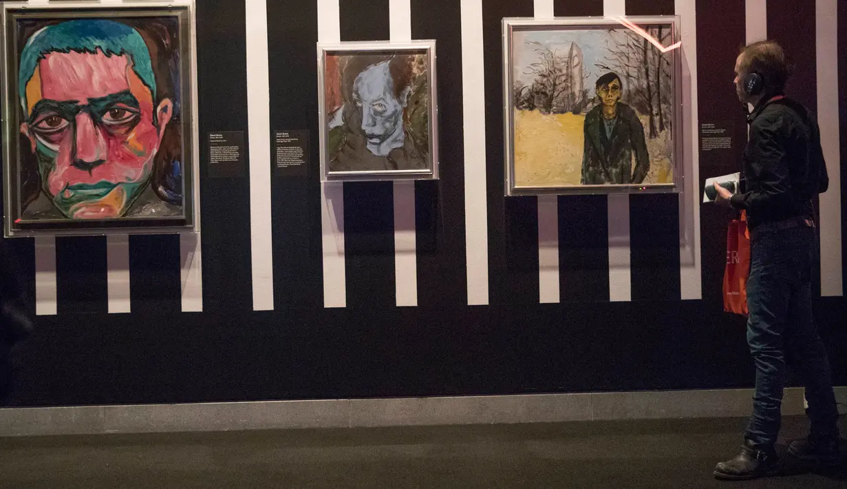 Pengunjung melihat karya seni lukisan yang dipajang dalam pameran "David Bowie" di Museum Brooklyn (28/2). Bowie menjadi karakter fiksi ilmiah untuk album The Rise and Fall of Ziggy Stardust and the Spiders from Mars. (AP Photo / Mary Altaffer)