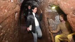 Pengunjung menuruni tangga di Terowongan Vinh Moc di Distrik Vinh Moc, Quang Tri, Vietnam, Kamis (18/1). Terowongan Vinh Moc merupakan satu di dari ribuan ribuan lorong bawah tanah yang dibangun di seluruh Vietnam selama perang. (AFP PHOTO/HOANG DINH NAM)