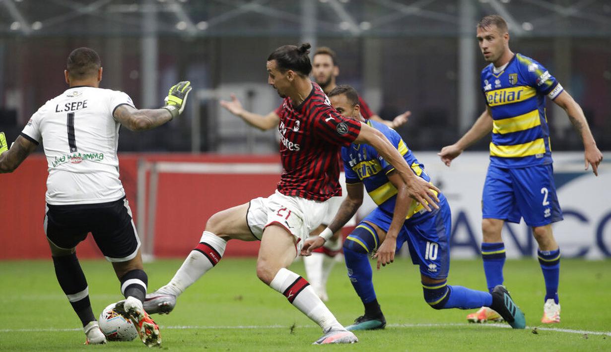 Striker AC Milan, Zlatan Ibrahimovic, berusaha melawati pemain Parma pada laga Serie A di Stadion San Siro, Rabu (15/7/2020). AC Milan menang 3-1 atas Parma. (AP Photo/Luca Bruno)