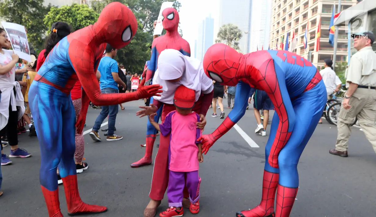 Dua orang dengan kostum Spiderman mennghibur seorang anak di CFD Jalan MH Thamrin, Jakarta, Minggu (6/8). Kegiatan amal ini untuk membantu anak-anak yatim piatu. (Liputan6.com/Fery Pradolo)