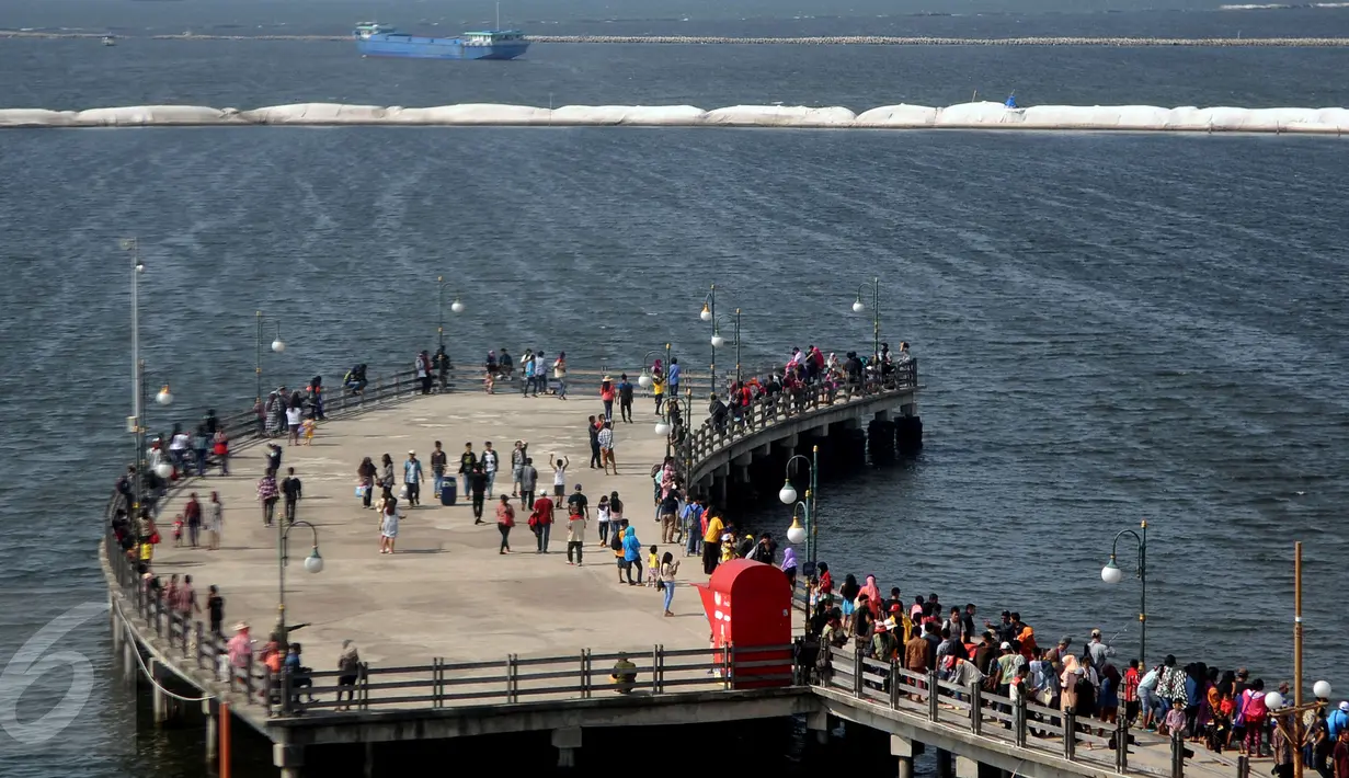 Pengunjung berada di dermaga cinta untuk menikmati suasana angin laut di Ancol, Jakarta, Sabtu (18/7/2015). Wisata pantai Ancol masih menjadi pilihan favorit warga Jakarta untuk mengisi libur lebaran kedua ini bersama keluarga. (Liputan6.com/JohanTallo)