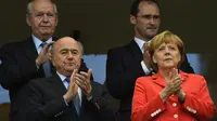 Bersama Persiden FIFA, Sepp Blatter (kiri - bawah), Kanselir Jerman, Angela Merkel memberikan applaus kepada para pemain yang berlaga di babak penyisihan Piala Dunia Grup G di Fonte Nova Arena, Brasil, (16/6/2014). (AFP PHOTO/Fabrice Coffrini)