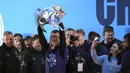 Pemain Manchester City Oleksandr Zinchenko mengangkat trofi di atas panggung disaksikan para penggemar saat parade kemenangan Liga Inggris di Manchester, Inggris, 23 Mei 2022. (AP Photo/Jon Super)