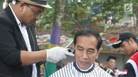 Presiden Joko Widodo saat mengikuti acara cukur rambut massal di Garut, Jawa Barat, Sabtu (19/1). Tak hanya Jokowi, Menteri PUPR Basuki Hadimuljono serta Kepala Sekretariat Presiden Heru Budi Hartono ikut memangkas rambutnya. (Liputan6.com/Angga Yuniar)