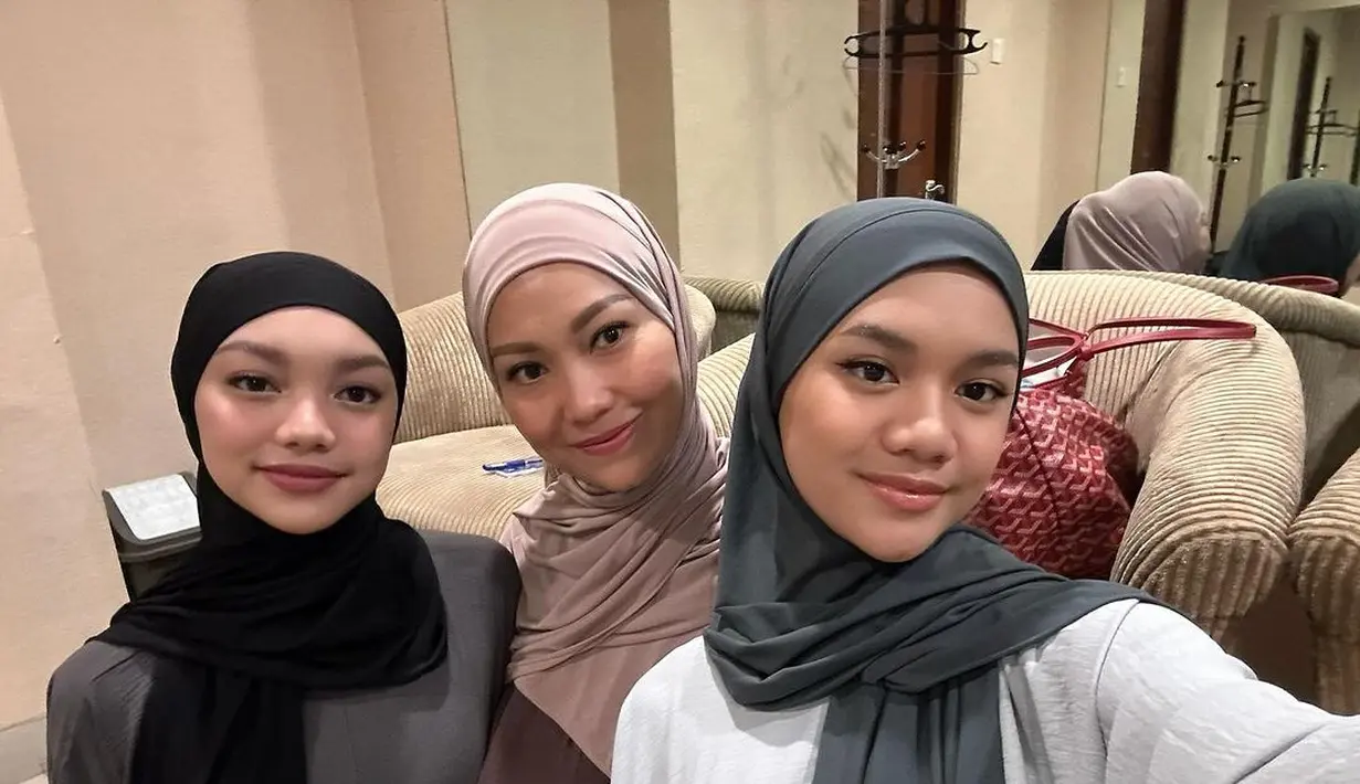 Tampil kontras dari kedua putrinya, Nola kenakan abaya cokelat tua dan hijab pashmina cokelat muda [@riafinola]