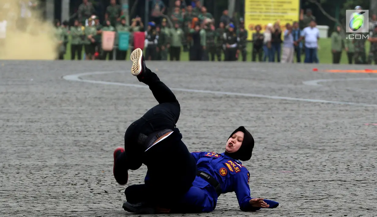 Prajurit Wanita Polri memamerkan aksi ilmu bela diri pada apel peringatan Hari Kartini 2018 di Lapangan Silang Monas, Jakarta, Rabu (25/4). Sebanyak 721 personel gabungan prajurit wanita TNI dan Polri melakukan atraksi. (Liputan6.com/Johan Tallo)