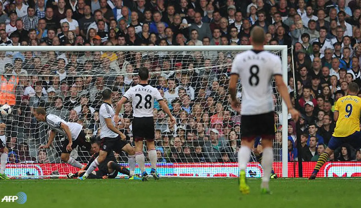 Tendangan keras Lukas Podolski berhasil membobol gawang Fulham pada pertandingan Liga Inggris antara Fulham melawan Arsenal di Stadion Craven Cottage, London Sabtu 24 Agustus 2013. (AFP/Carl Court)