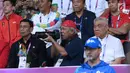 Menteri PUPR, Basuki Hadimuljono bersiap mengabadikan momen saat laga semifinal bulu tangkis beregu putra Asian Games 2018, Indonesia melawan Jepang di Jakarta, Selasa (21/8). Indonesia unggul dan lolos ke final. (Liputan6.com/Helmi Fithriansyah)