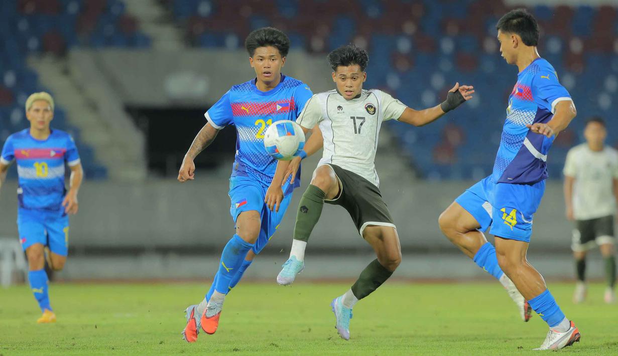Sayang, hingga akhir pertandingan, skor tidak berubah. Timnas Indonesia U-22 kalah 0-1 dari Filipina. Tampak dalam foto, pemain Timnas Indonesia U-22, Rahmat Arjuna Reski (tengah) mencoba melewati adangan dua pemain Filipina, Jaime Rosquillo (14) dan Santiago Rublico (21), pada laga perdana Grup C SEA Games 2025 di Stadion 700th Anniversary, Chiang Mai, Thailand, Senin (8/12/2025). (Bola.com/Bagaskara Lazuardi)