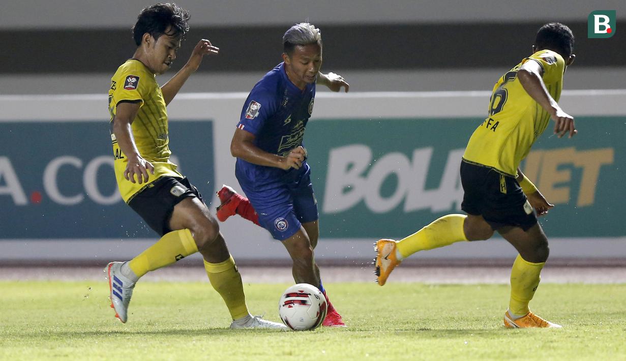 Striker Arema FC, Dendi Santoso (tengah) berusaha melewati dua pemain Barito Putera dalam laga matchday ke-2 Grup A Piala Menpora 2021 di Stadion Manahan, Solo, Kamis (25/3/2021). Arema FC sementara tertinggal 0-2 dari Barito Putera di babak pertama. (Bola.com/Arief Bagus)