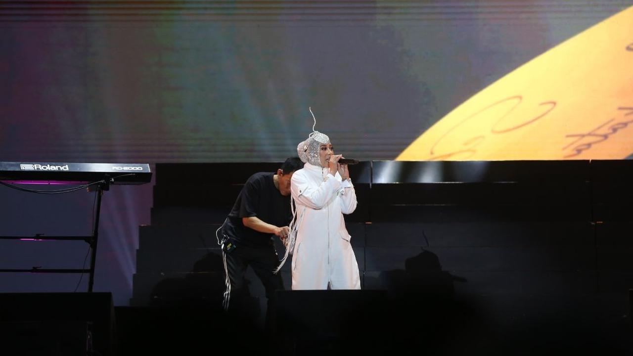 Dalam penampilannya, penyanyi berusia 49 tahun itu dalam balutan busana putih dan hijab dengan aksesoris unik di atas kepalanya.