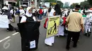 Sejumlah relawan membawa kantong plastik besar dan spanduk bertuliskan "Throw A HOAX, Here Please" di tengah aksi damai 4 November di Jakarta, Jumat (4/11). Mereka mengumpulkan sampah yang dibuang anggota ormas. (Liputan6.com/Faizal Fanani)