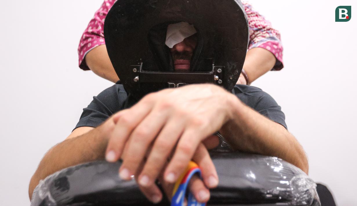 Seorang jurnalis asing menikmati fasilitas pijat saat Piala Dunia FIBA 2023 di Indonesia Arena, Senayan, Jakarta, Jumat (01/09/2023). (Bola.com/Bagaskara Lazuardi)