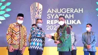 Direktur Bisnis dan Kewirausahaan KNEKS Putu Rahwidhiyasa (tengah) memberikan penghargaan kepada Direktur Consumer PT Bank Tabungan Negara (Persero) Tbk. Hirwandi Gafar (kanan) kategori Unit Usaha Syariah-Bank Syariah Terbaik dalam ajang Anugerah Syariah Republika (ASR) di Jakarta (29/11/2022). (Liputan6.com)
