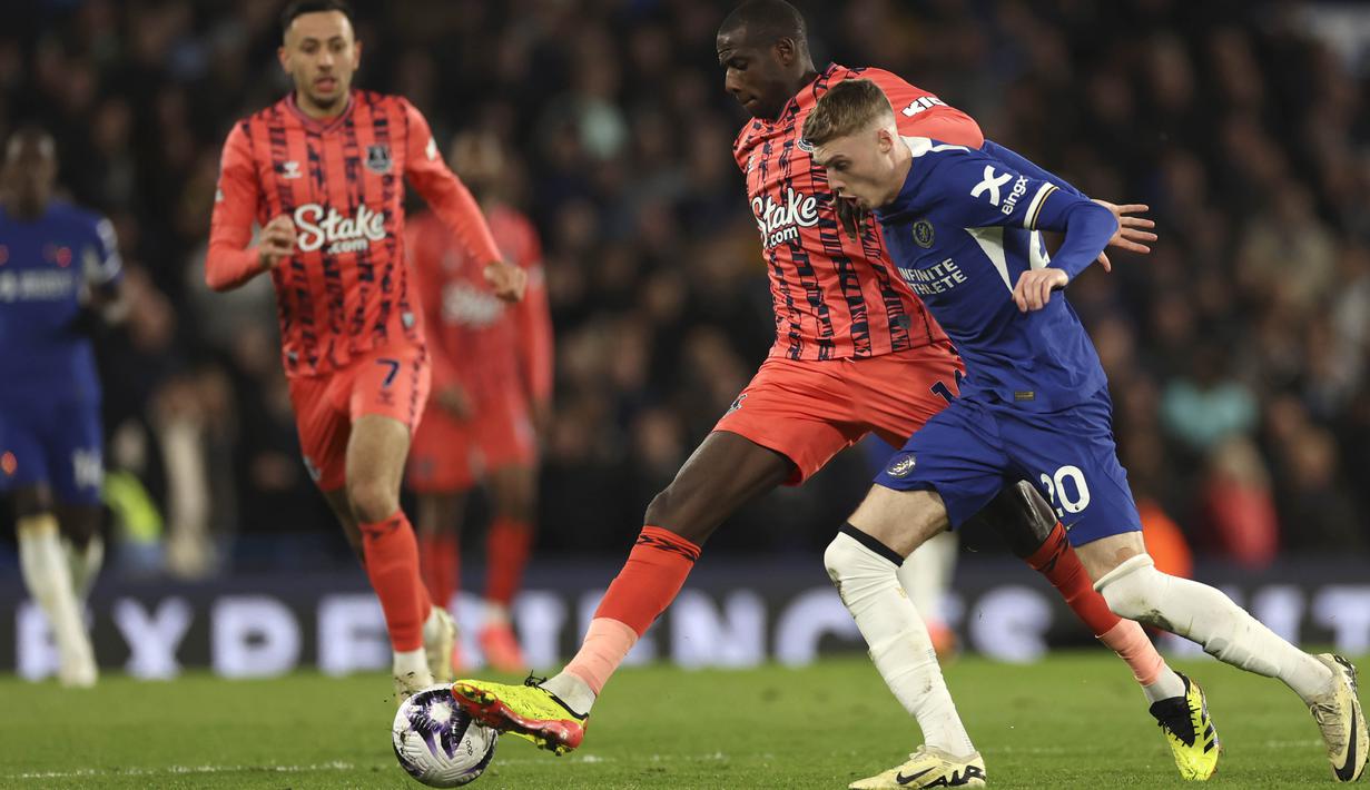 Pemain Chelsea, Cole Palmer, berebut bola dengan pemain Everton, Abdoulaye Doucoure, pada laga pekan ke-33 Liga Inggris di Stadion Stamford Bridge, Selasa (16/4/2024). (AP Photo/Ian Walton)