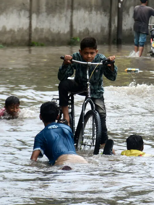 Anak-anak bermain di tengah banjir setelah hujan lebat mengguyur Lahore, Punjab, Pakistan, 20 Agustus 2020. Sebanyak 18 orang tewas dan banyak lainnya terluka akibat hujan lebat di Punjab. (Xinhua/Sajjad)
