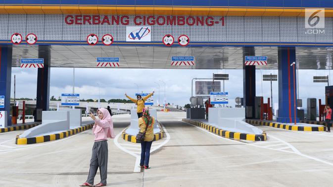 Beberapa warga berfoto berlatar gerbang tol Cigombong I di Cigombong, Kab Bogor, Jawa Barat, usai diresmikan, Sabtu (1/12). Ruas panjang tol Ciawi-Sukabumi Seksi I Ciawi-Cigombong sejauh 15,3 kilometer. (Liputan6.com/Helmi Fithriansyah)